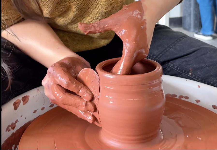 Person working with clay on a pottery wheel